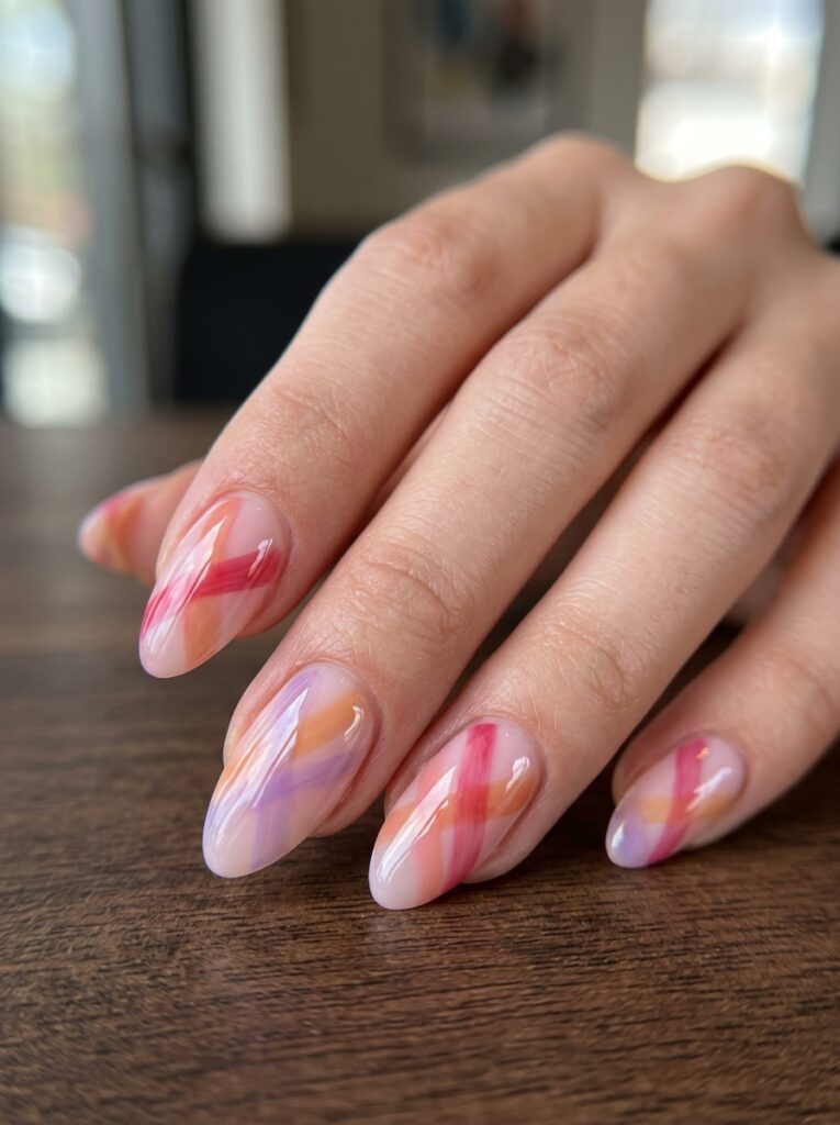 Extreme close-up of medium almond nails with a soft milky pink base and overlapping translucent jelly stripes in rose, peach, and lilac, the overlapping sections blending into new shades like stained glass, thick glossy top coat, hand posed gracefully with fingers softly fanned against a dark walnut café table, bright natural window light, 100mm macro lens, shallow depth of field, editorial beauty photography