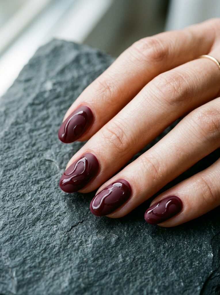 matte bordeaux nails with glossy swirls