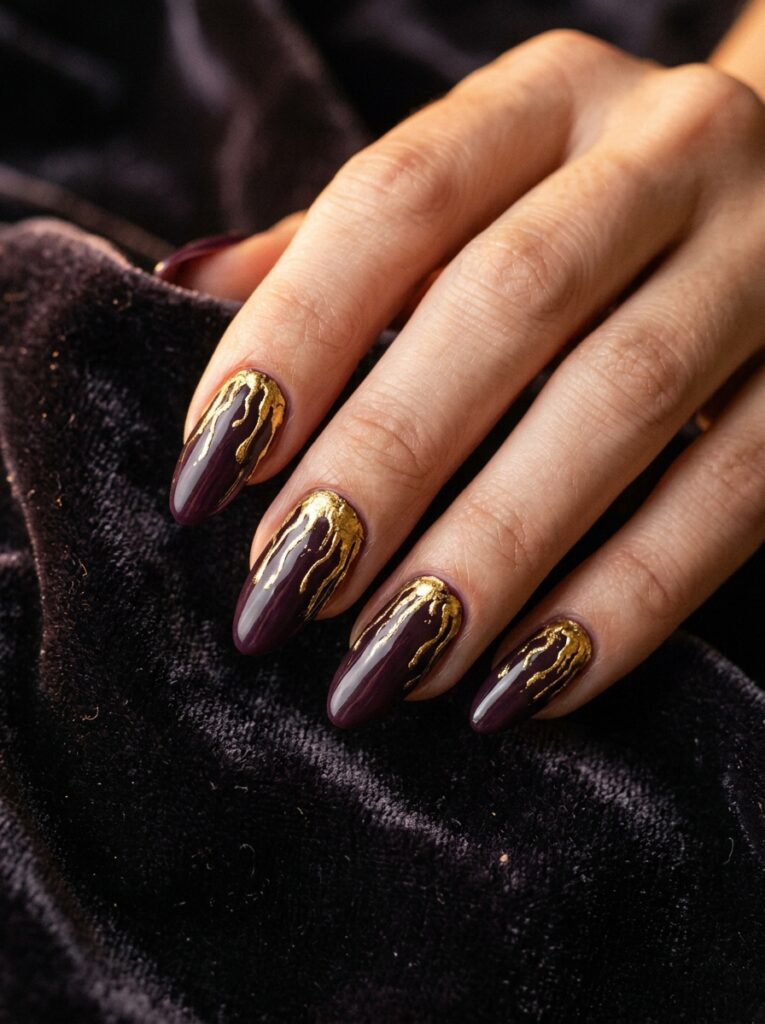molten gold drips on dark plum nails